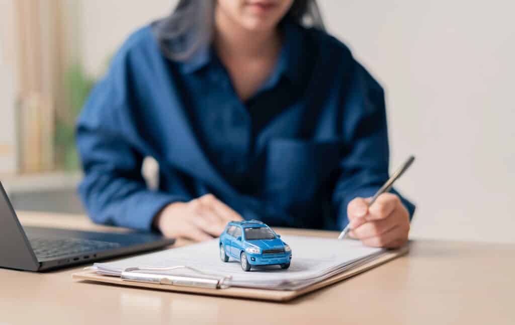 Individual,Signing,Auto,insurance,Documents,At,A,Desk,With,A