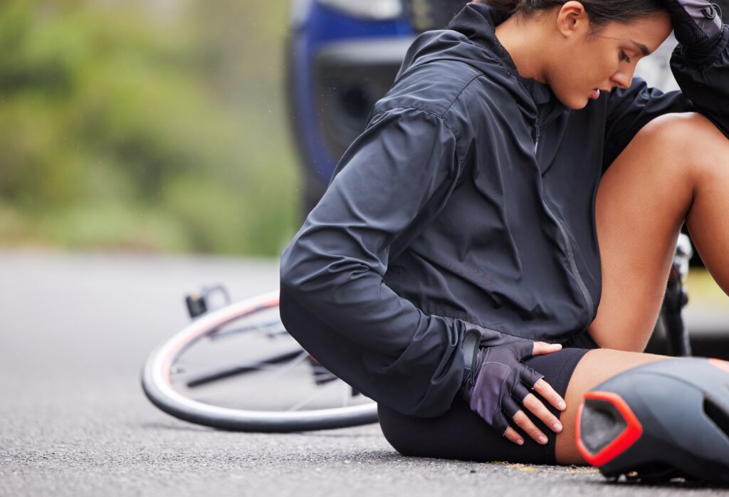 Cyclist on ground injured with car in background